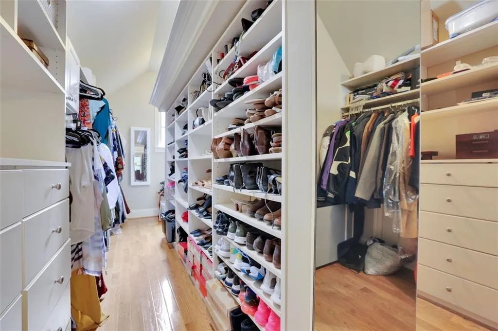 Master Walk U-shaped his/her closet with light hardwood / wood-style flooring