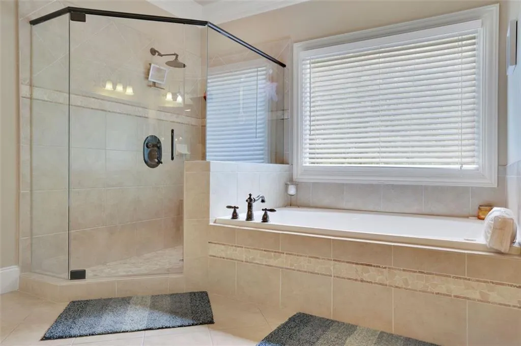Master Bathroom with independent shower and bath, a healthy amount of sunlight, and tile floors