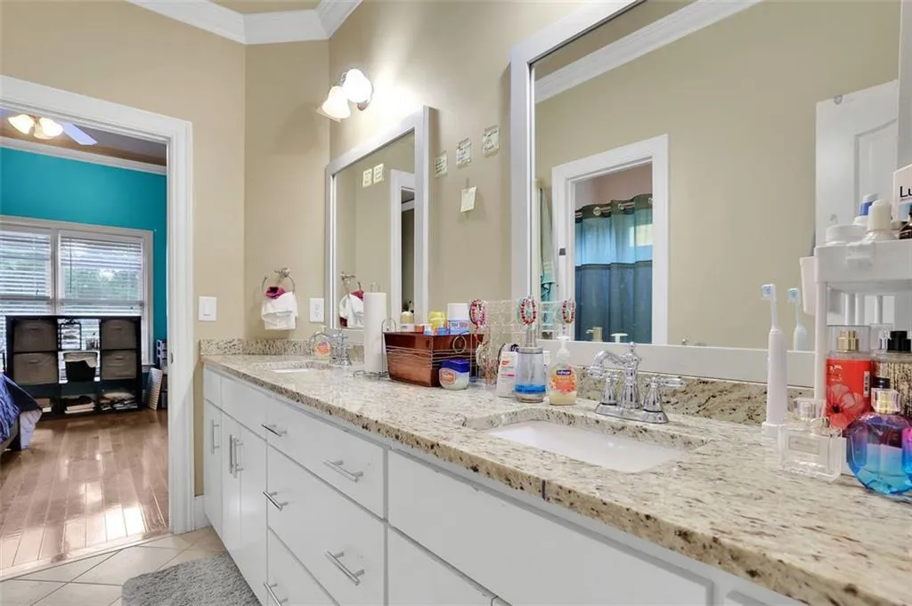 Jack & Jill Bathroom featuring double sink, crown molding, oversized vanity, and hardwood / wood-style floors