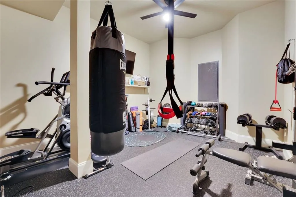 Workout area featuring ceiling fan with gym flooring