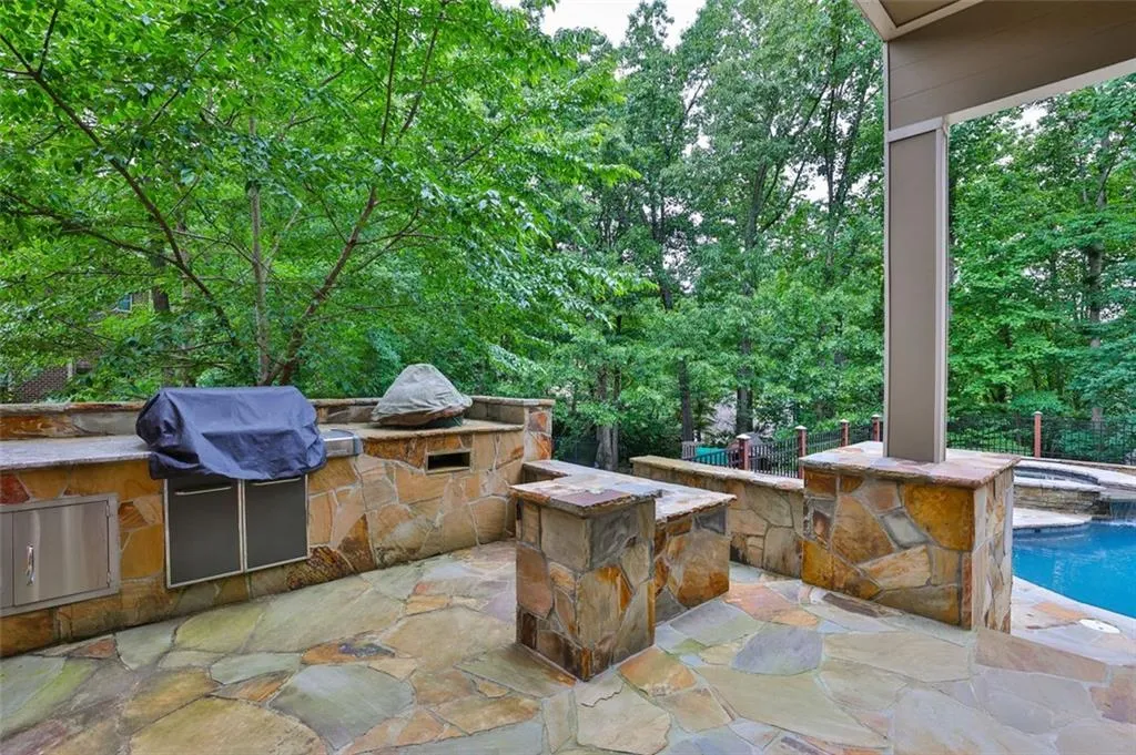 View of terrace (sub basement/pool level) featuring a grill and area for grilling