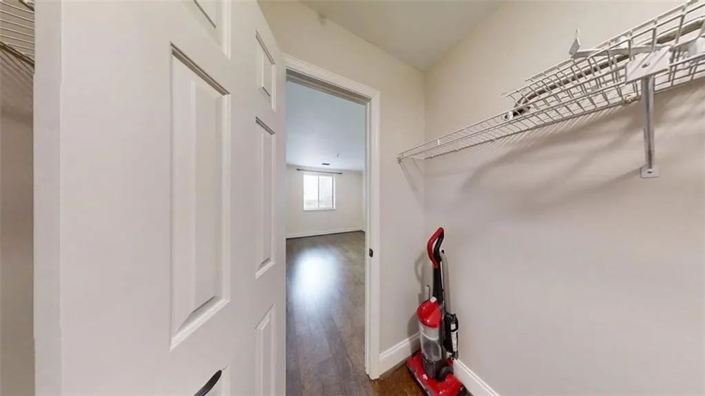Walk in closet featuring dark wood finished floors