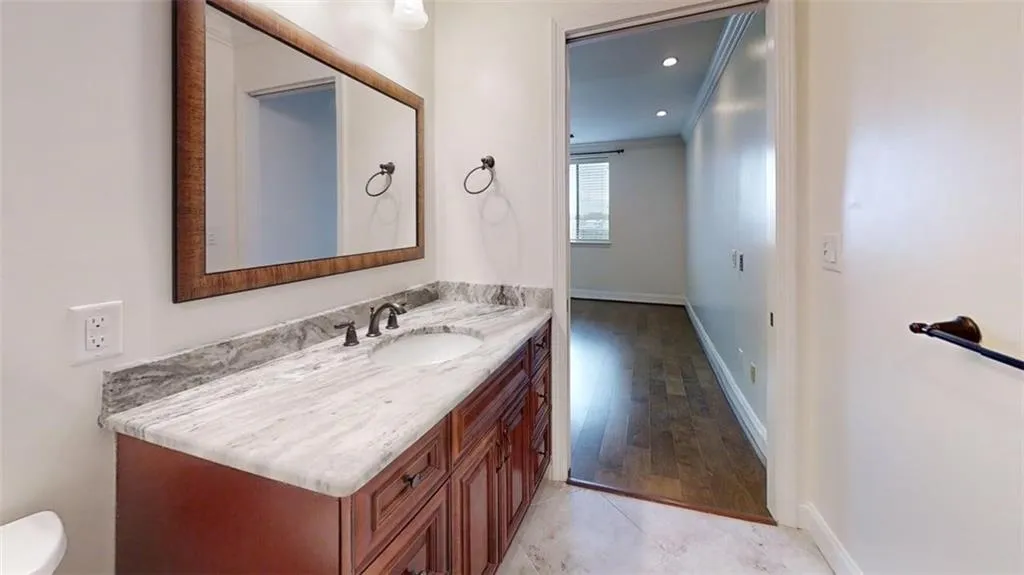 Half bathroom with vanity, crown molding, light tile patterned floors, and recessed lighting