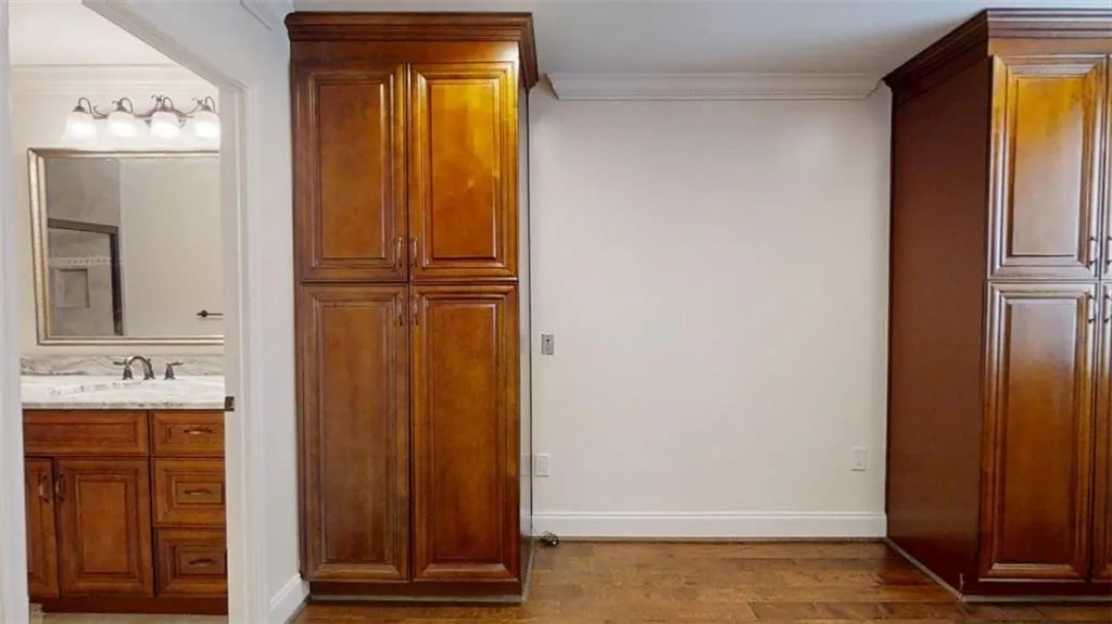 Bathroom with dark wood finished floors, vanity, and crown molding