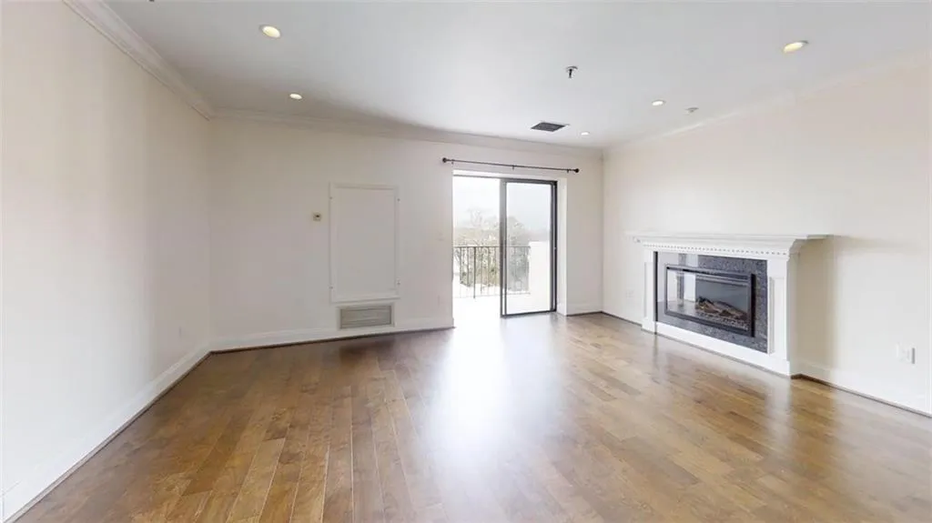 Unfurnished living room featuring a high end fireplace, light wood-style floors, recessed lighting, and ornamental molding