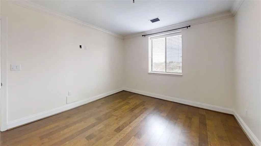 Unfurnished room with ornamental molding and dark wood-style floors