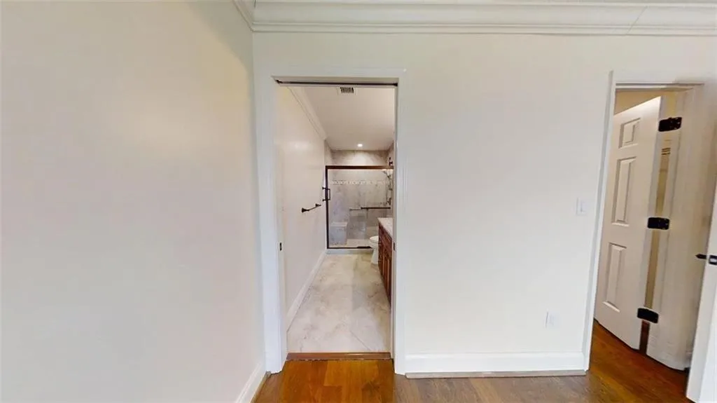 Hallway featuring crown molding and light wood-style floors
