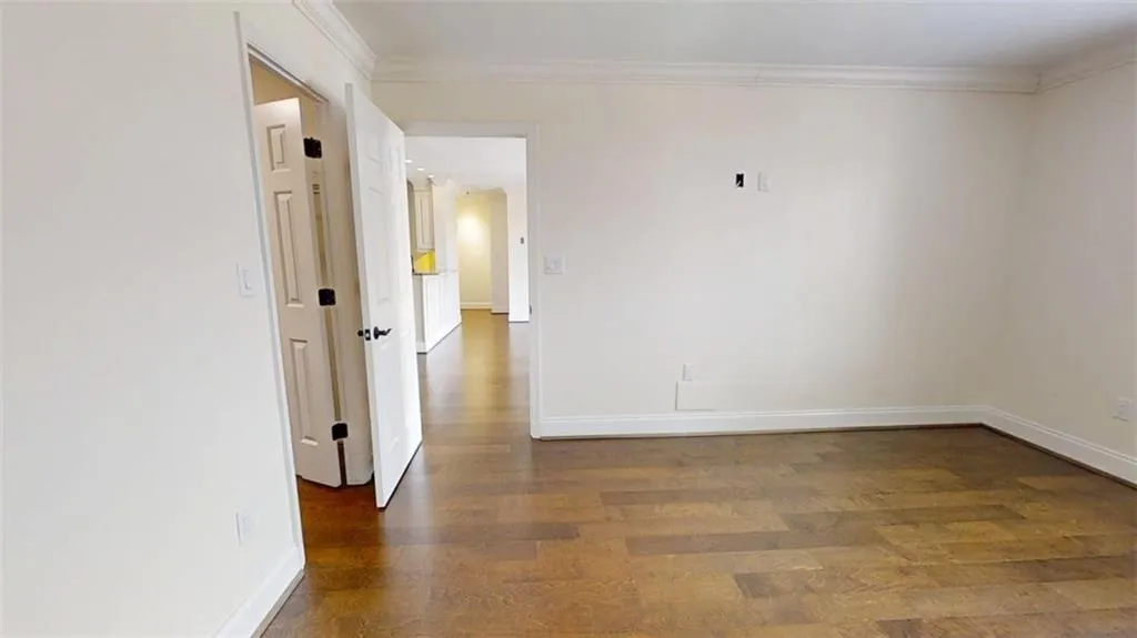 Spare room with dark wood-style floors and crown molding