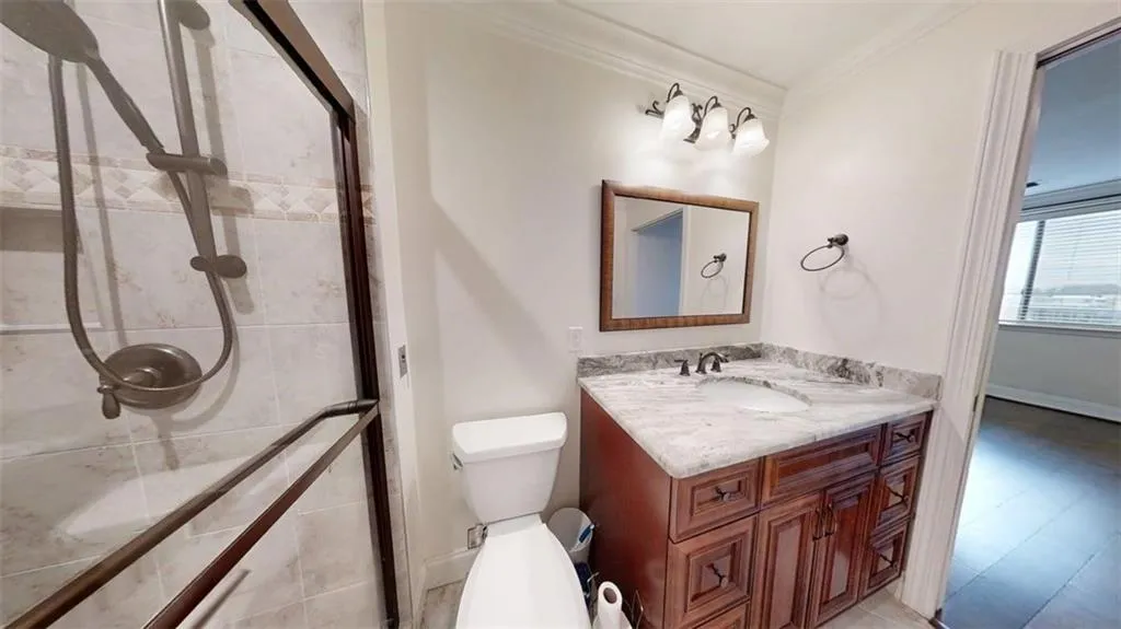 Bathroom featuring vanity, crown molding, and a stall shower