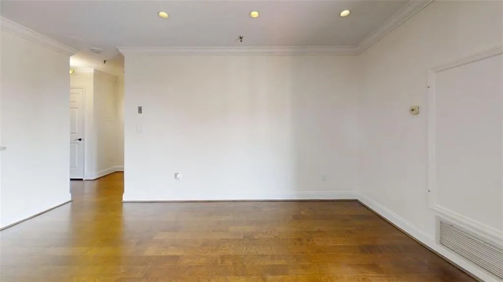 Unfurnished room featuring recessed lighting, dark wood-style floors, and ornamental molding