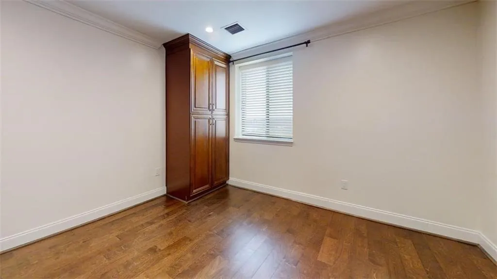 Unfurnished bedroom with dark wood finished floors, crown molding, and recessed lighting