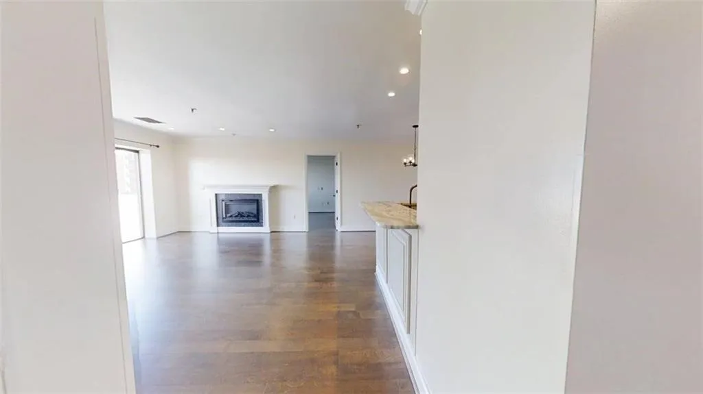 Unfurnished living room with recessed lighting, dark wood finished floors, and a fireplace