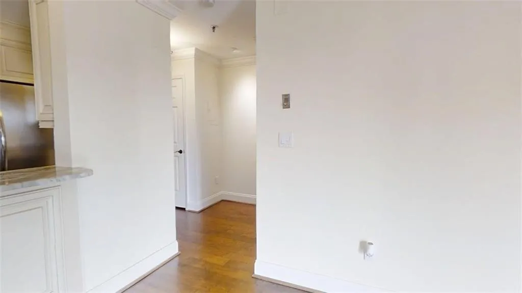 Hallway featuring dark wood-type flooring and ornamental molding