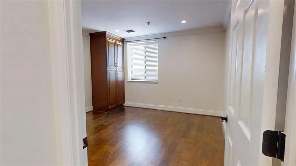Unfurnished room with dark wood-style flooring, ornamental molding, and recessed lighting