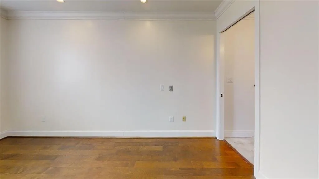Spare room featuring wood finished floors, crown molding, and recessed lighting