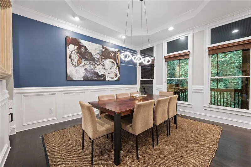 Another photo of the same dining room space with updated light fixture and art. Here you can see the covered screened in patio just beyond the windows... Open the windows for fresh air and a truly cohesive gathering with people inside and outside of this perfectly created gathering space!