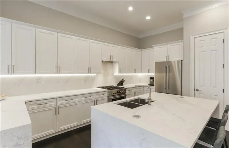 Gorgeous chef's kitchen with upgraded leather quartz waterfall countertops and tons of cabinet and counter space. You will love creating and making memories here!