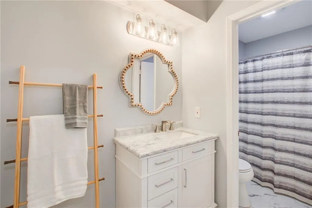 Beautiful bathroom with new  tile flooring, vanity and lighting.