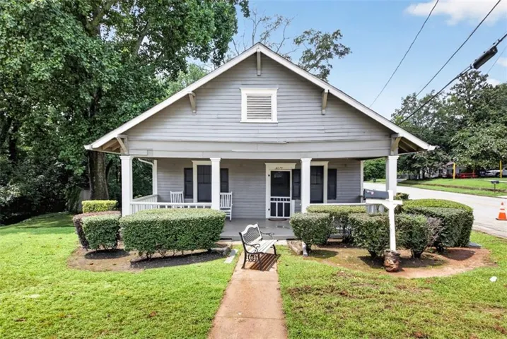 Craftsman-style home featuring a covered front porch with white columns and railing