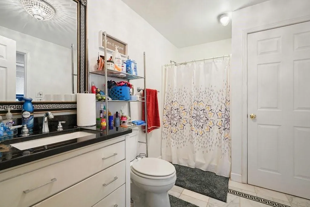 Bathroom with vanity, light tile patterned flooring, and a shower