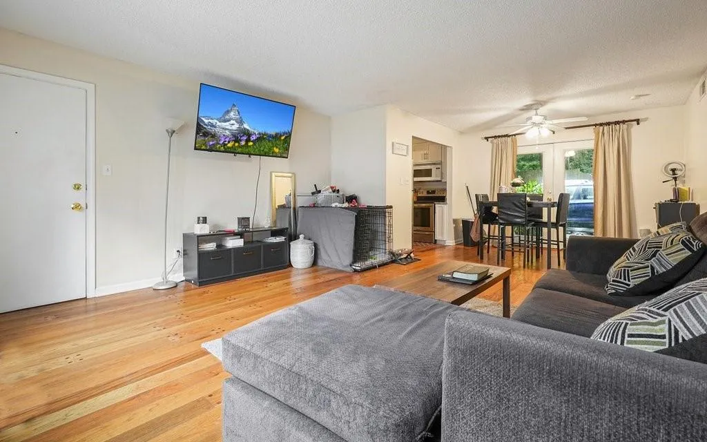 Living area with light hardwood floors, french doors, ceiling fan, and a textured ceiling
