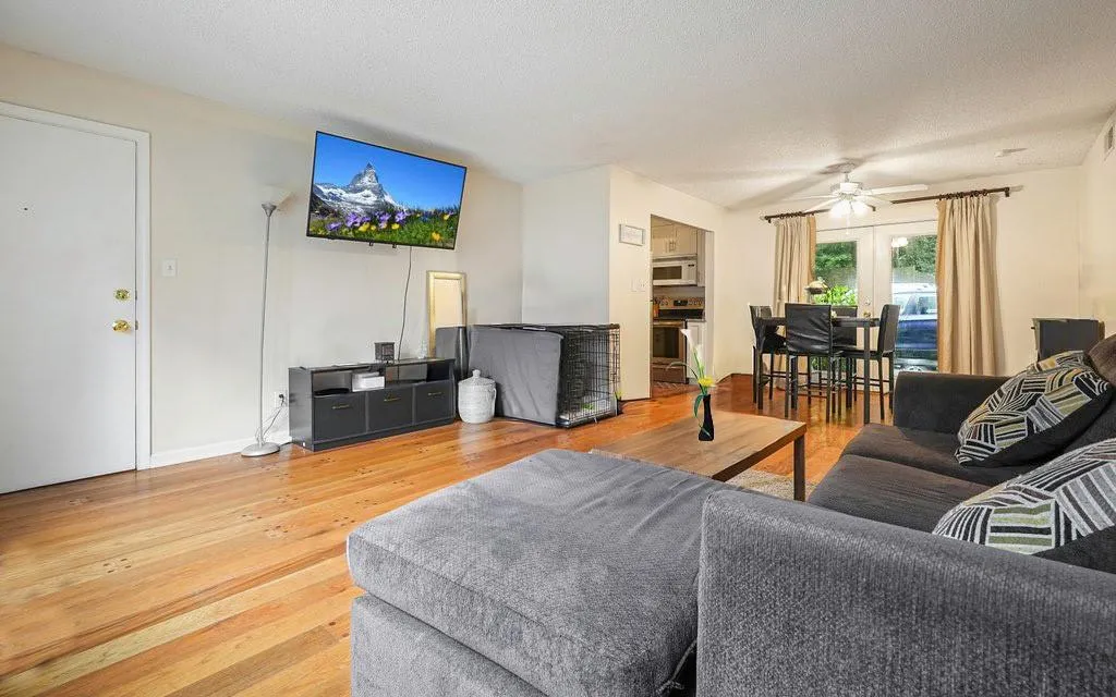 Living room featuring light wood-style floors, french doors, ceiling fan, and a textured ceiling