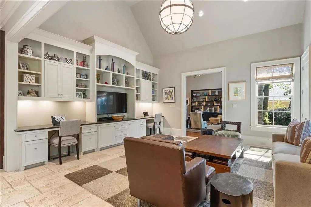 The keeping room features expansive cabinetry and built in shelving with two desk spaces for schoolwork or work from home days.