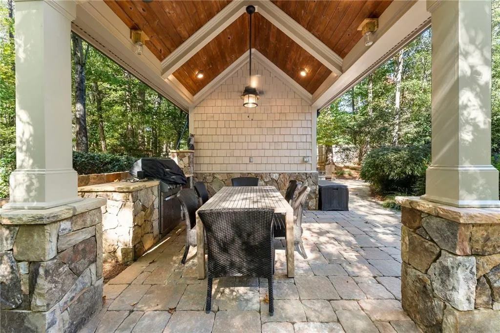 The pool house features a covered outdoor cooking space and full bathroom.