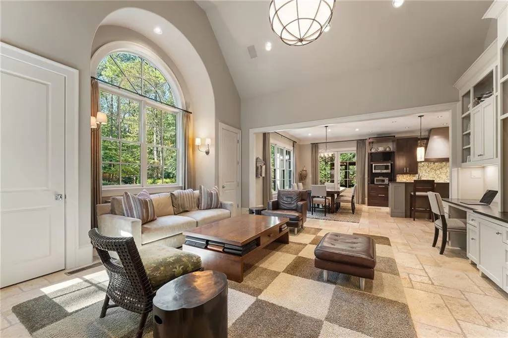 The oversized keeping room features a dramatic arched window and conveniently connects the living room and kitchen space.