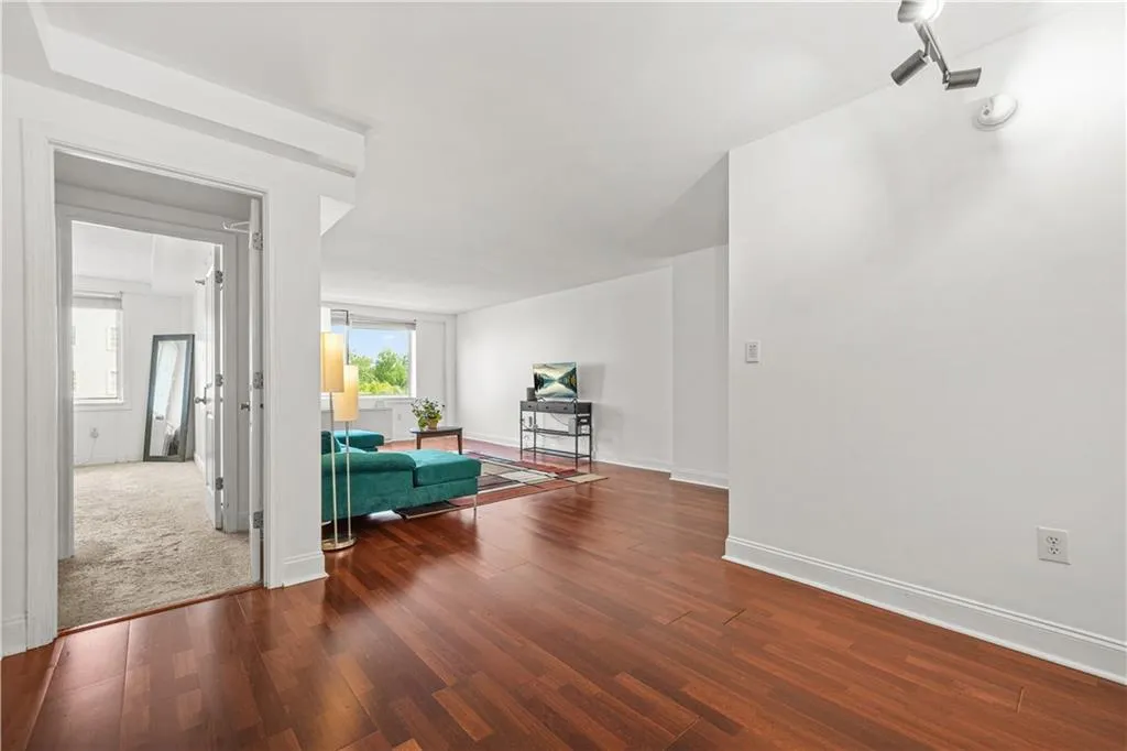 Living area featuring dark wood-style flooring and baseboards