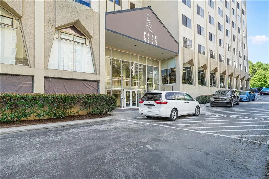 View of building exterior featuring uncovered parking