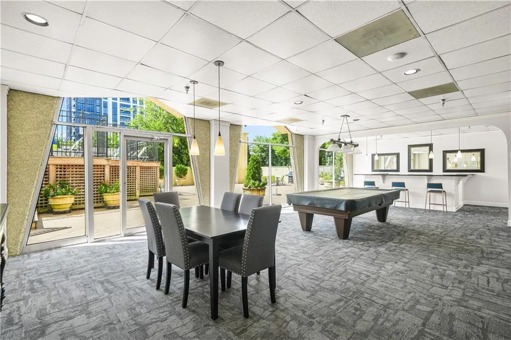 Game room with a paneled ceiling, carpet floors, billiards table, and a wall of windows