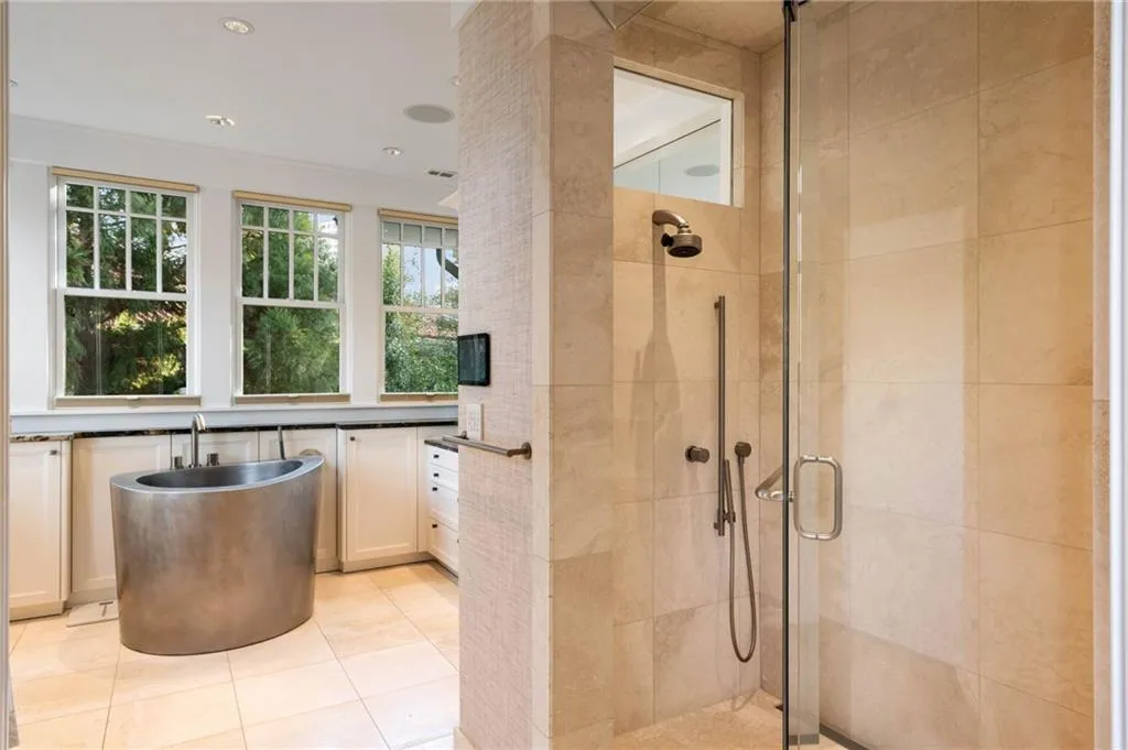 Full bath featuring a stall shower, light tile patterned floors, a freestanding tub, and recessed lighting