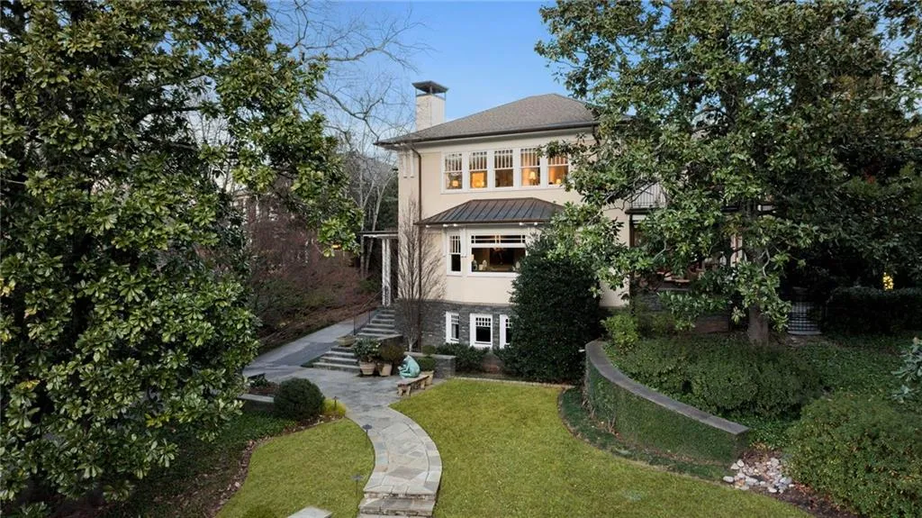 Front view of house with a chimney, a yard, a patio area, a standing seam roof, and a metal roof