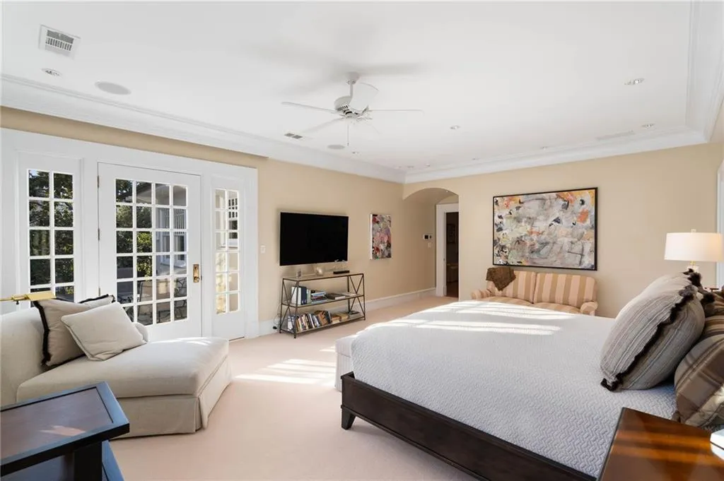 Bedroom featuring carpet, access to exterior, ceiling fan, arched walkways, and ornamental molding