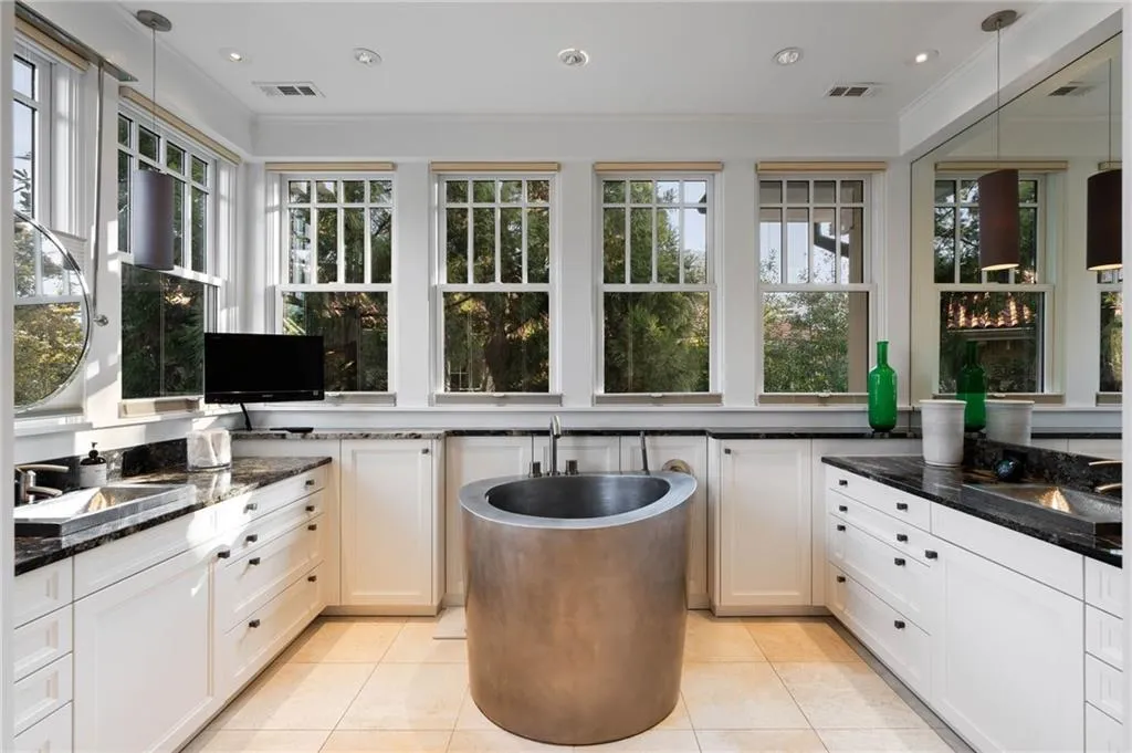 Kitchen with decorative light fixtures, dark stone counters, white cabinets, crown molding, and recessed lighting