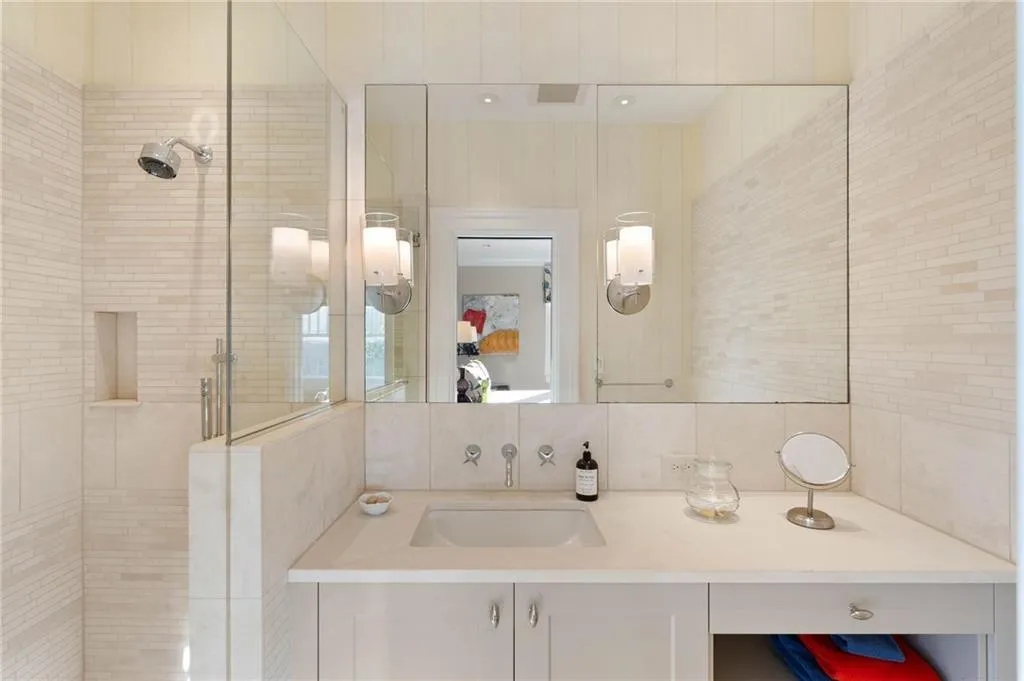 Ensuite bathroom featuring a stall shower, vanity, and decorative backsplash