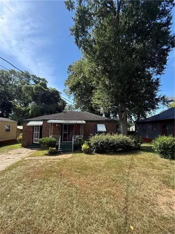 Brick exterior with a covered entry, front steps, and mature landscaping