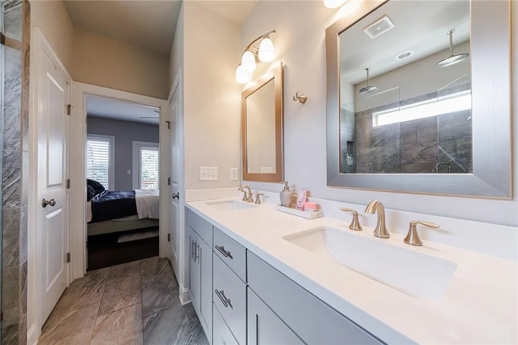 Double vanity with modern fixtures and stone top.