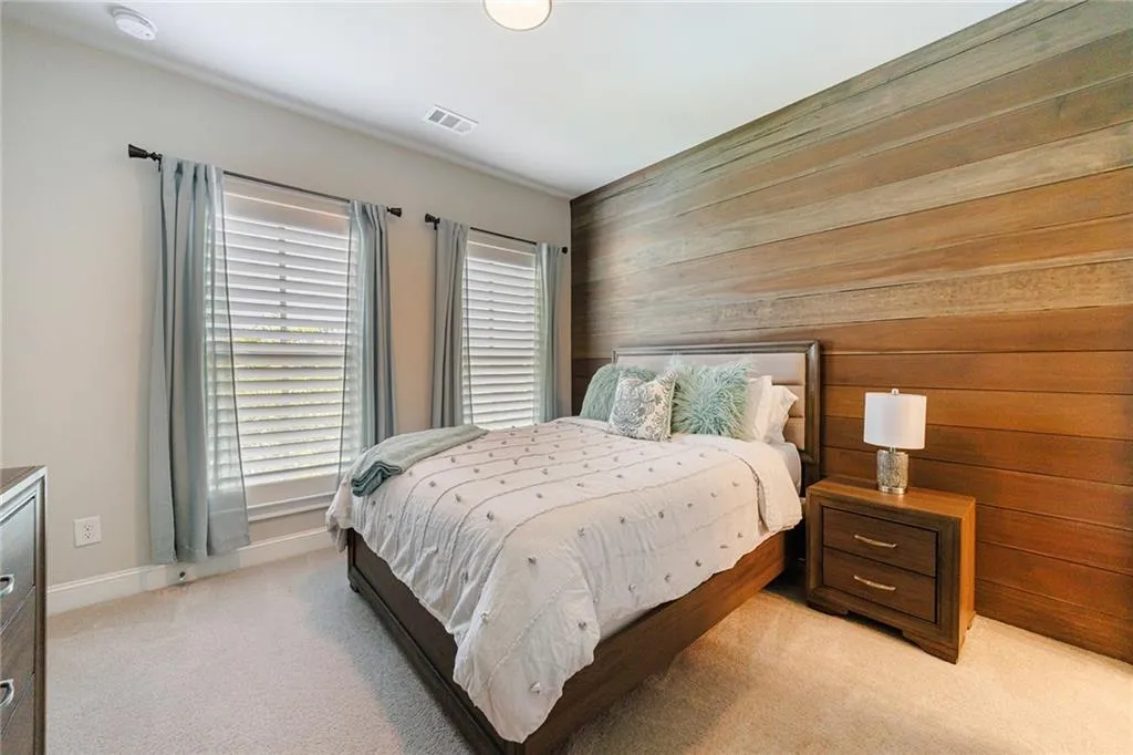 The secondary bedroom also features a wood accent wall, creating a cozy and inviting space