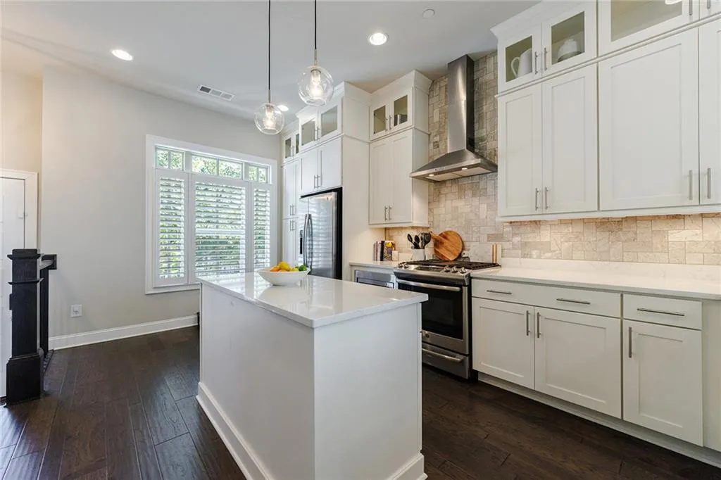 Elegant stone backsplash and ceiling height cabinets enhance the lovely kitchen.