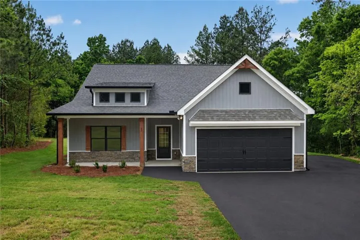 Modern farmhouse-style facade featuring gray siding and stone accents