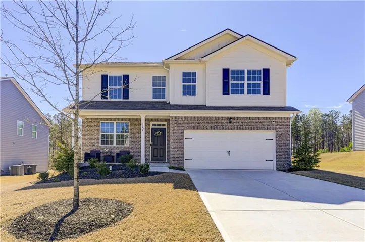 Two-story exterior featuring brick and siding, a covered front entry, and a two-car garage