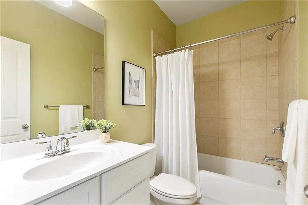 Full bathroom with shower / tub combo, vanity, and toilet