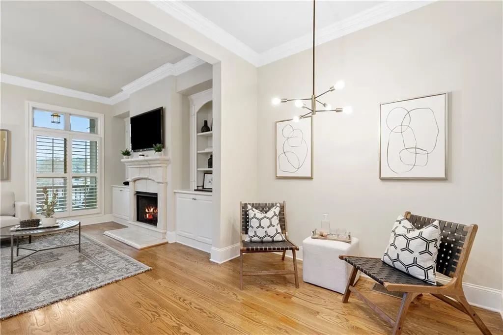 Sitting room featuring crown molding, built in features, a chandelier, and light hardwood / wood-style floors