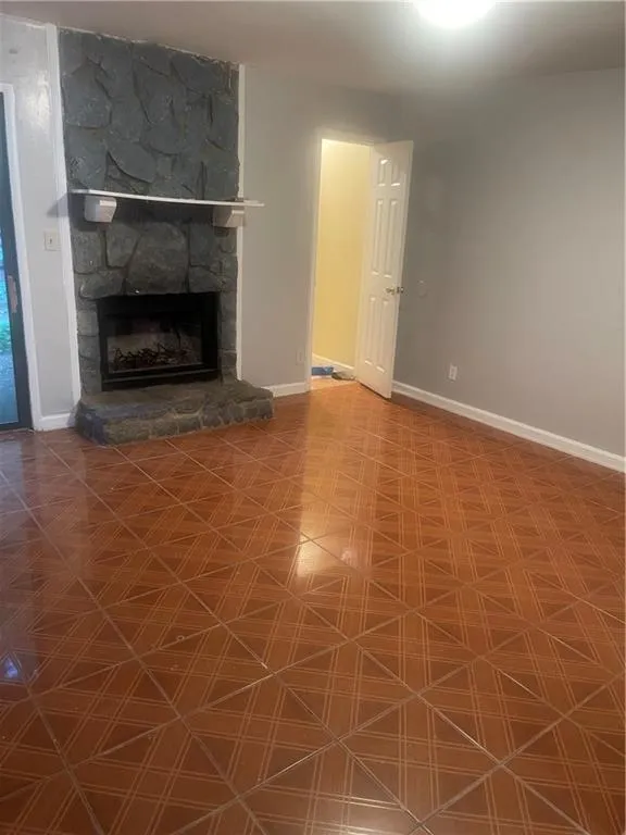 Unfurnished living room featuring a stone fireplace
