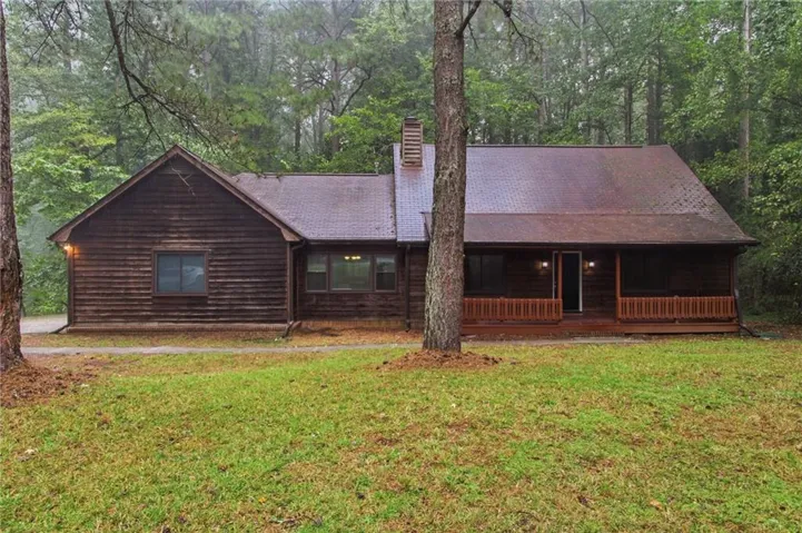 Wood-sided exterior featuring a gable roofline and a covered porch with wood railings