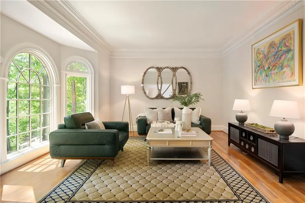 The formal living room is bathed in natural light from arched windows, offering a versatile space ideal for relaxing or the perfect spot for a sunny office.
