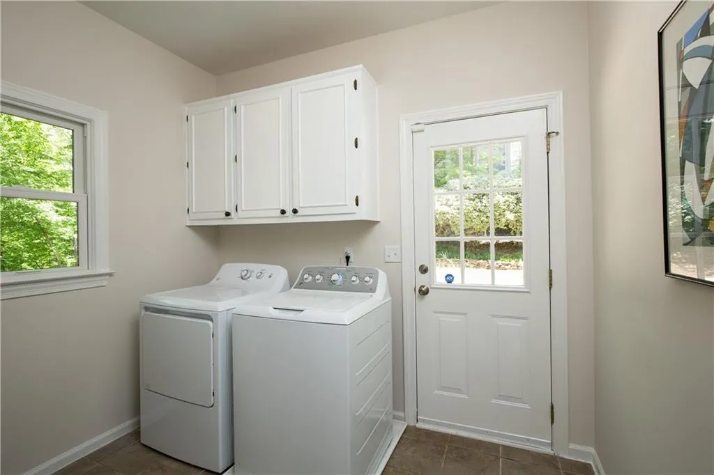 A well-appointed laundry room with sink adds convenience, complete with ample storage and direct exterior access.