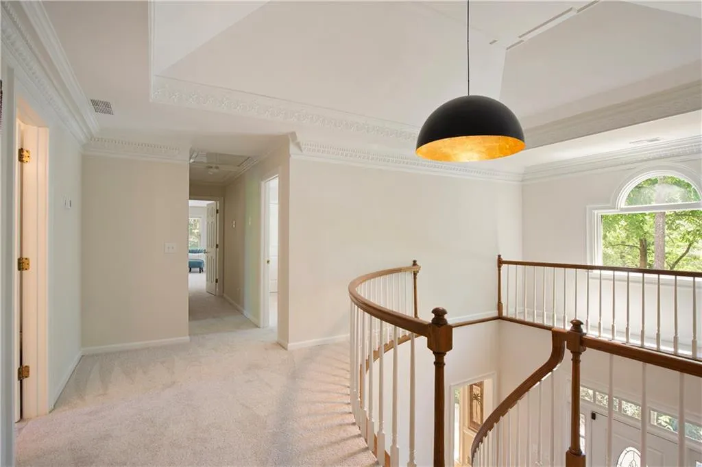 The upper-level landing overlooks the foyer below, enhancing the home’s open feel with elegant architectural detail.